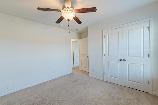 unfurnished bedroom with light carpet, ceiling fan, and a closet