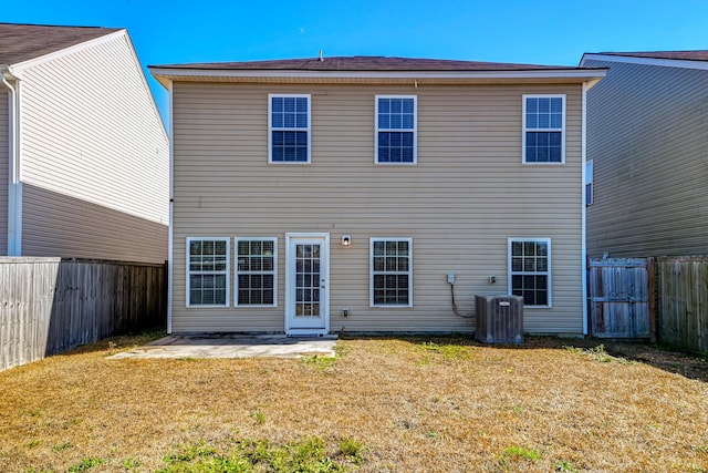 back of property featuring central AC unit, a yard, and a patio