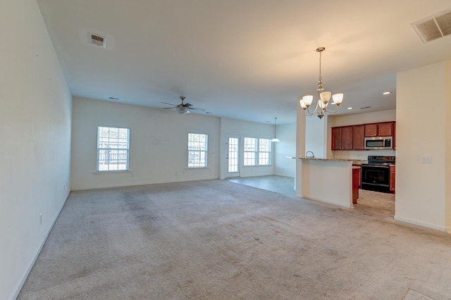 unfurnished living room with light colored carpet and ceiling fan with notable chandelier