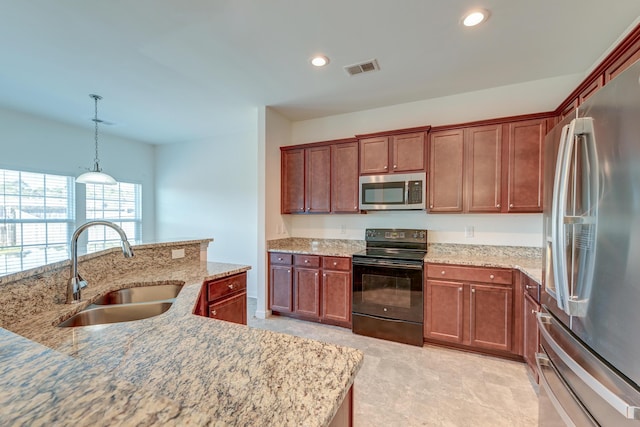 kitchen featuring pendant lighting, sink, stainless steel appliances, and light stone countertops