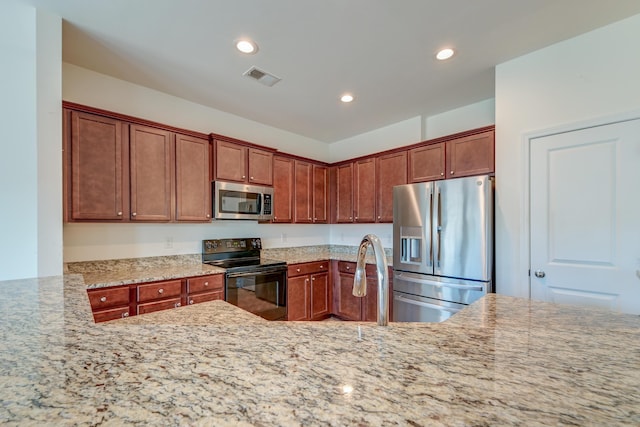 kitchen featuring light stone countertops, appliances with stainless steel finishes, sink, and kitchen peninsula