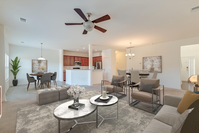 living room with ceiling fan with notable chandelier