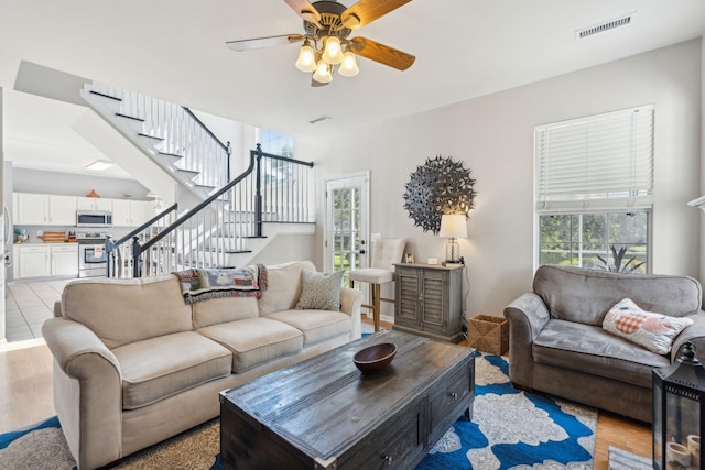 living room featuring light hardwood / wood-style flooring and ceiling fan