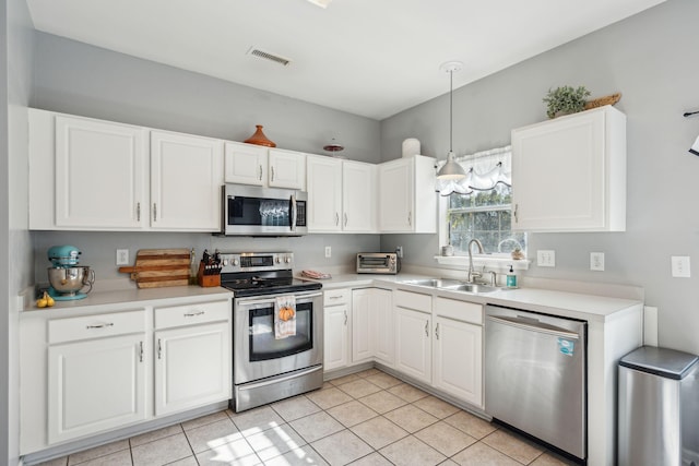 kitchen with white cabinetry, sink, light tile patterned floors, and appliances with stainless steel finishes