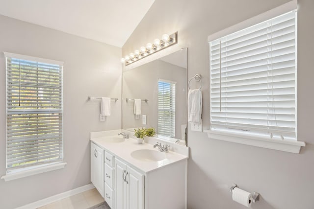 bathroom with tile patterned flooring, vanity, and vaulted ceiling