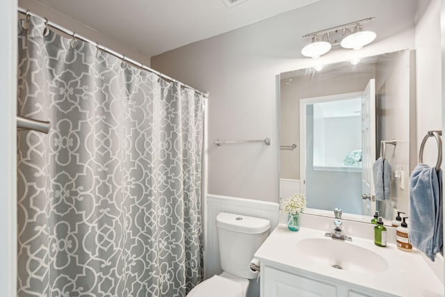 bathroom with vanity, curtained shower, and toilet