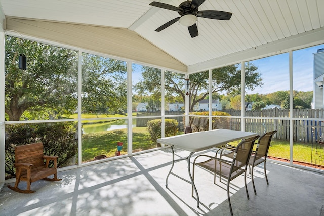 sunroom / solarium with a water view, lofted ceiling, and ceiling fan