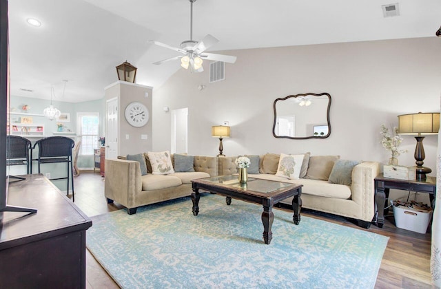 living area with light wood-style floors, lofted ceiling, visible vents, and ceiling fan