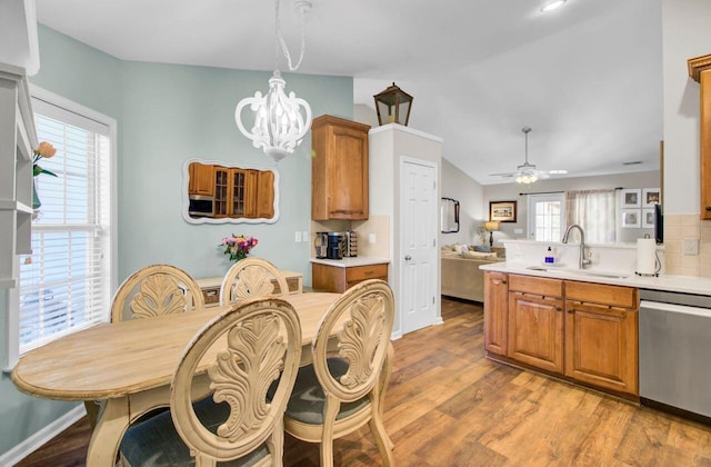 dining room featuring lofted ceiling, light wood-style flooring, and ceiling fan with notable chandelier