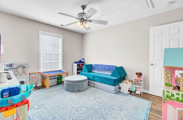 game room featuring baseboards, wood finished floors, a ceiling fan, and attic access