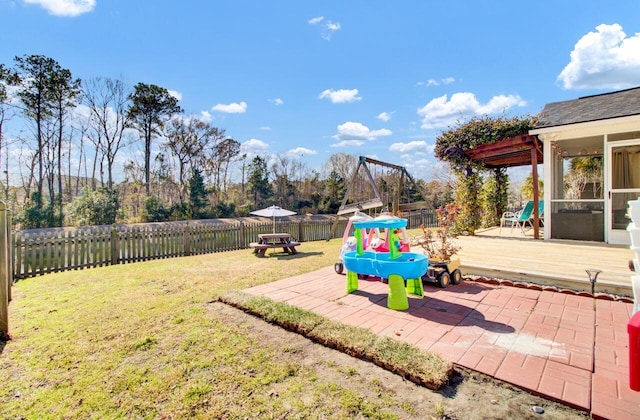 view of yard featuring a patio area, a fenced backyard, and a sunroom