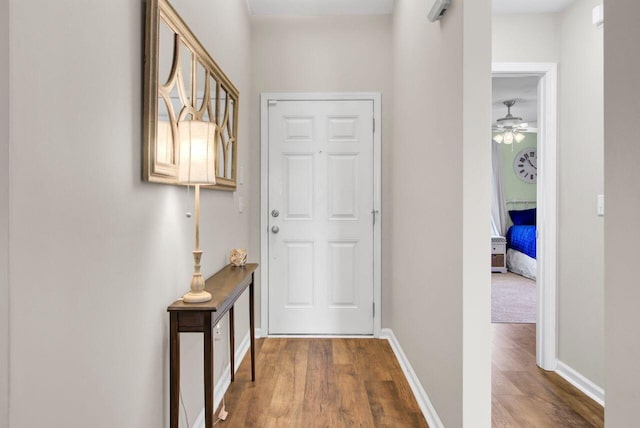 entryway with a ceiling fan, baseboards, and wood finished floors