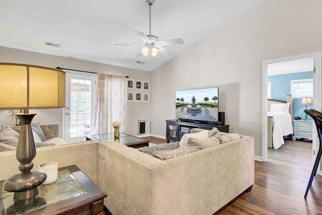 living area featuring lofted ceiling, baseboards, visible vents, and dark wood-type flooring