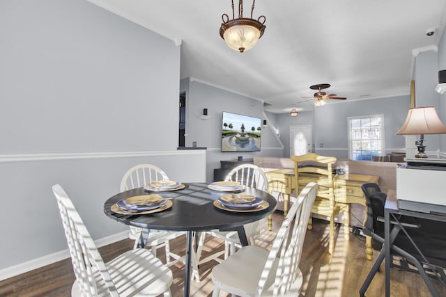 dining area with ceiling fan, dark wood-type flooring, and ornamental molding