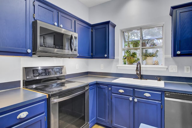 kitchen featuring blue cabinetry, sink, and appliances with stainless steel finishes