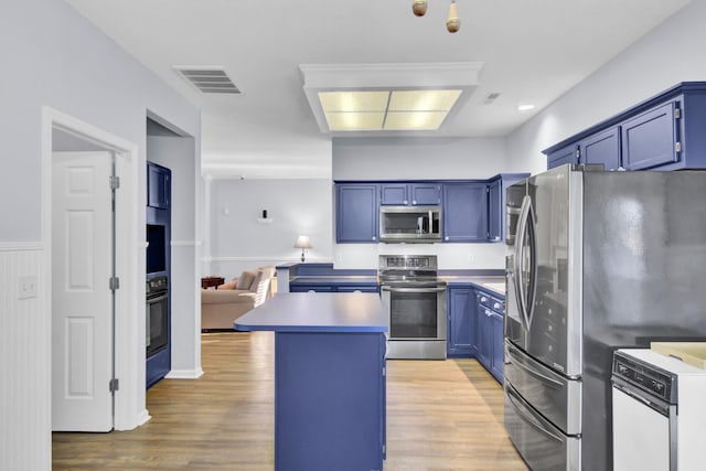 kitchen featuring a center island, wood-type flooring, blue cabinets, and appliances with stainless steel finishes