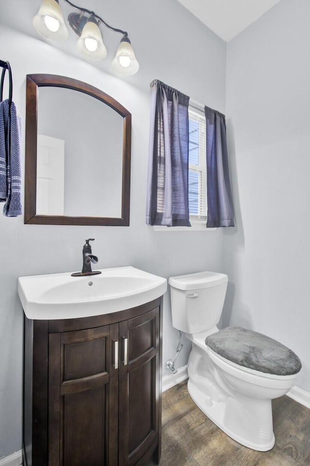 bathroom with hardwood / wood-style flooring, vanity, and toilet