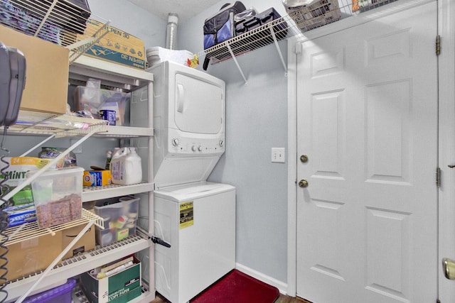 clothes washing area featuring stacked washer / drying machine