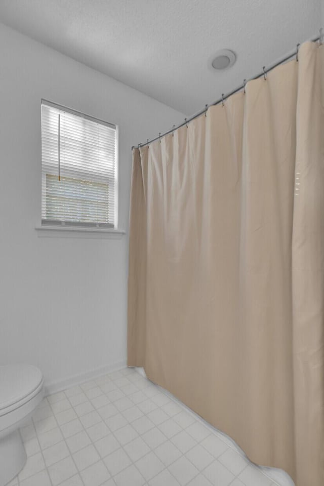 bathroom featuring a textured ceiling and toilet