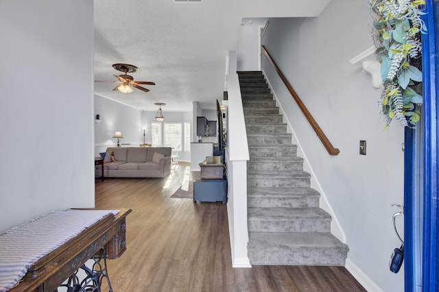 stairs with ceiling fan and wood-type flooring