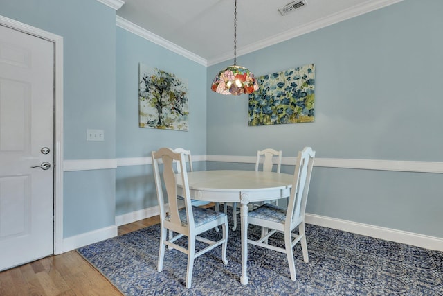 dining area featuring hardwood / wood-style flooring and ornamental molding