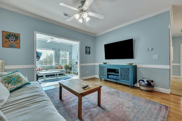 living room featuring wood-type flooring, ceiling fan, and ornamental molding