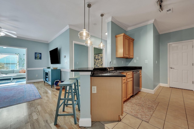 kitchen with dishwasher, a kitchen breakfast bar, sink, hanging light fixtures, and kitchen peninsula