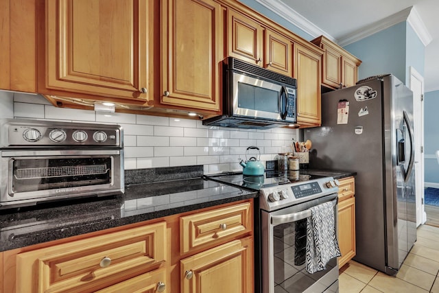 kitchen with decorative backsplash, appliances with stainless steel finishes, dark stone counters, crown molding, and light tile patterned floors