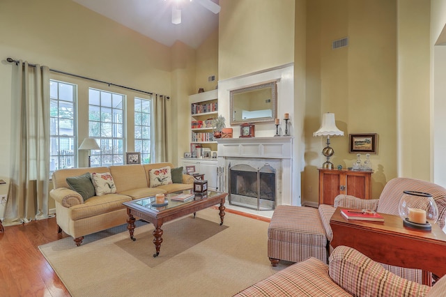 living room featuring a towering ceiling and light hardwood / wood-style floors