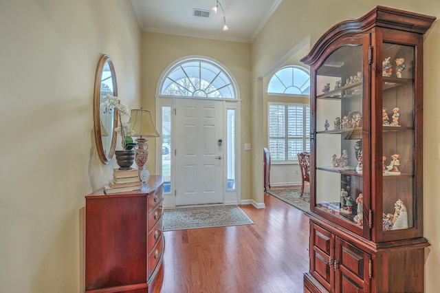 foyer entrance with hardwood / wood-style flooring and ornamental molding