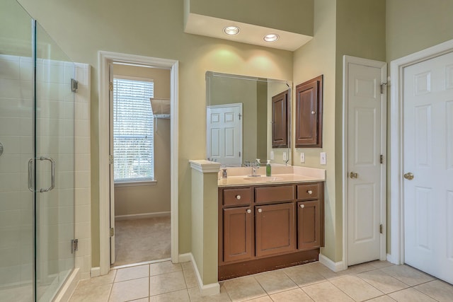 bathroom featuring walk in shower, vanity, and tile patterned flooring