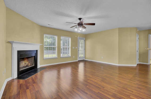 unfurnished living room with ceiling fan, dark hardwood / wood-style floors, and a textured ceiling