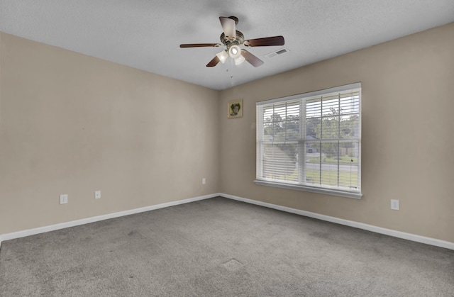 unfurnished room with ceiling fan, carpet flooring, and a textured ceiling