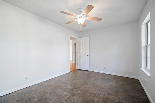 spare room with a textured ceiling, a healthy amount of sunlight, and ceiling fan