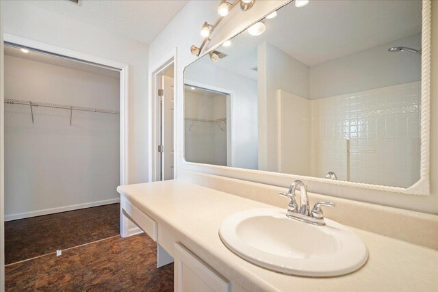 bathroom featuring walk in shower and vanity