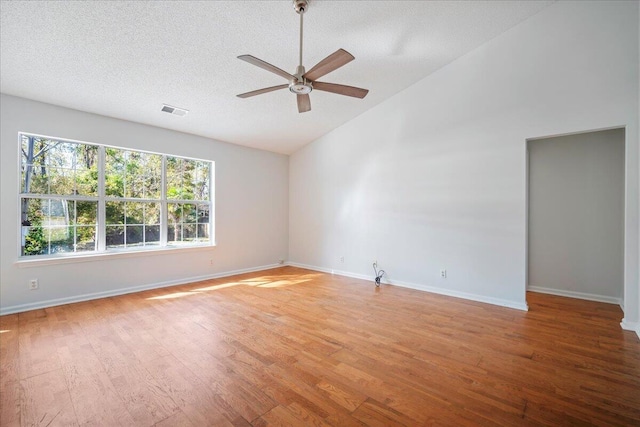 spare room with light hardwood / wood-style floors, ceiling fan, a textured ceiling, and high vaulted ceiling