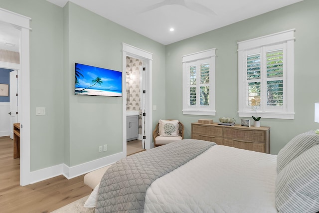 bedroom featuring connected bathroom, ceiling fan, and light hardwood / wood-style floors