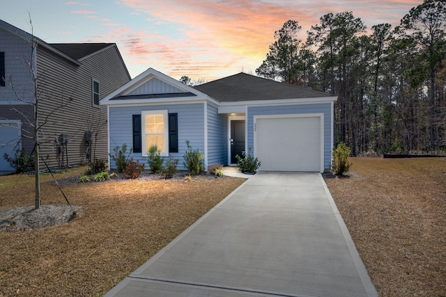 ranch-style home with a garage, concrete driveway, and board and batten siding