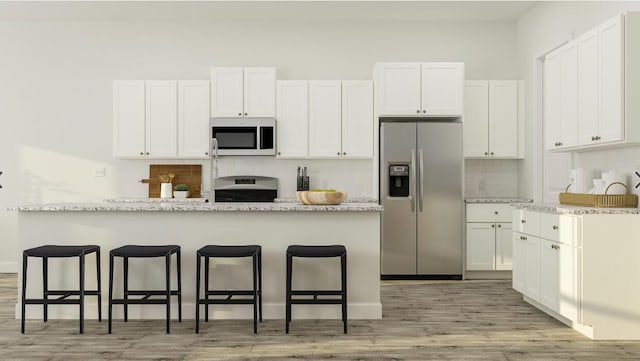 kitchen with a breakfast bar, white cabinetry, stove, light stone counters, and stainless steel fridge with ice dispenser