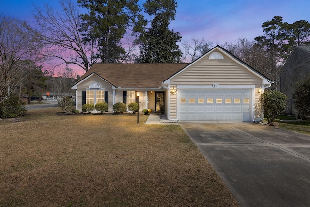 ranch-style home with a garage, driveway, and a front yard