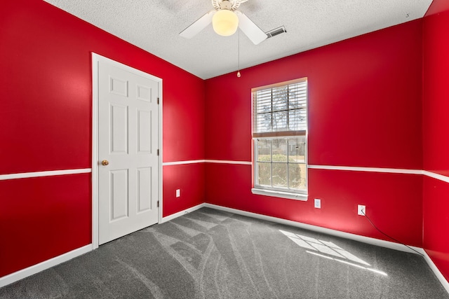 unfurnished room featuring a textured ceiling, ceiling fan, carpet floors, visible vents, and baseboards