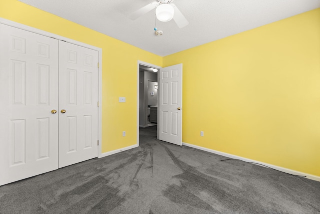 unfurnished bedroom with dark colored carpet, a closet, a ceiling fan, and baseboards