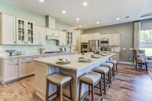 120 Magnolia House Dr, Summerville, SC 29486 - kitchen featuring appliances with stainless steel finishes, light wood-type flooring, a breakfast bar area, decorative backsplash, and recessed lighting
