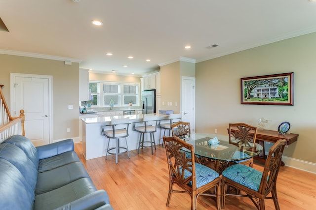 dining area with recessed lighting, visible vents, baseboards, light wood-style floors, and crown molding