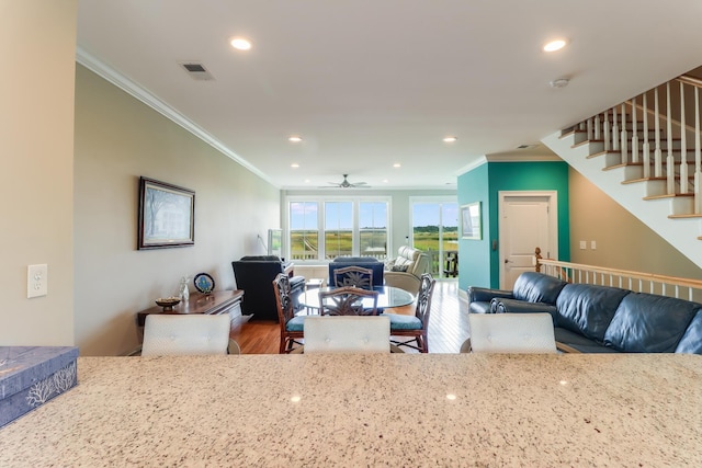 kitchen with open floor plan, visible vents, crown molding, and wood finished floors