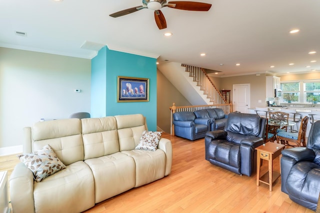 living area with light wood-style floors, recessed lighting, stairway, and ornamental molding