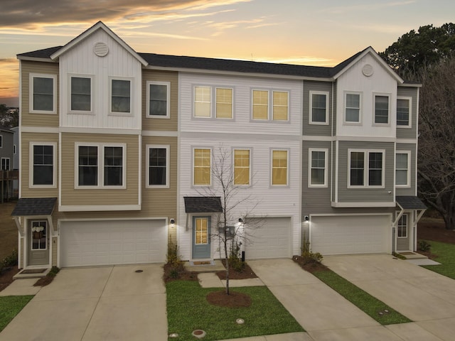 view of property with board and batten siding, concrete driveway, and an attached garage