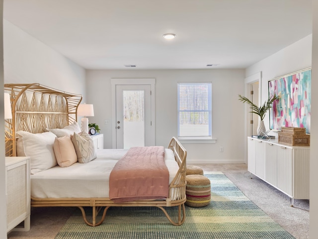 bedroom with light carpet, access to outside, visible vents, and baseboards