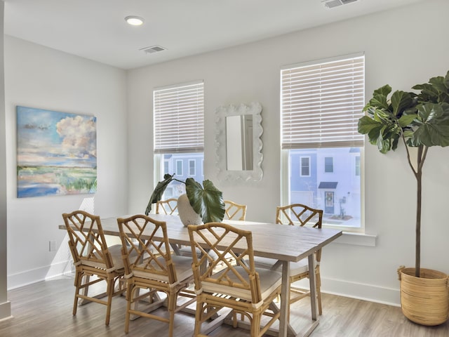 dining room featuring wood finished floors, visible vents, and baseboards