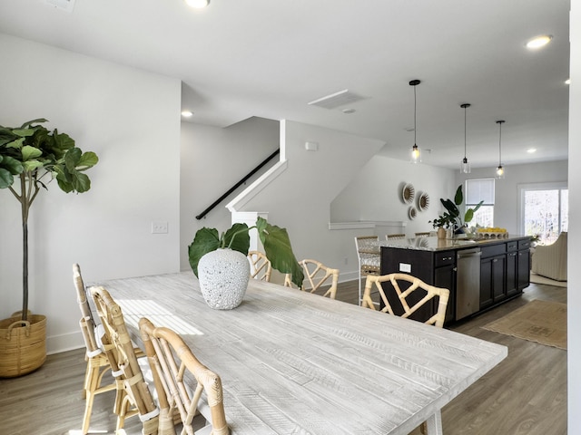 dining room with baseboards, wood finished floors, visible vents, and recessed lighting